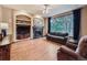 Cozy living room featuring a fireplace, built-in shelving, and a large window with tree view at 19748 E Pinewood Dr, Aurora, CO 80016