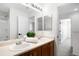 Bathroom featuring double sinks with chrome fixtures, a large mirror and a view of the bathtub/shower at 17200 Waterhouse Cir # D, Parker, CO 80134