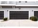 Attached two-car garage featuring paneled doors and exterior lighting that enhances the curb appeal of the home at 17200 Waterhouse Cir # D, Parker, CO 80134