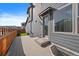Back deck of home with outdoor lighting, exterior door, and view of nearby houses and fenced in yard at 6805 Canosa St, Denver, CO 80221