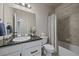 Bathroom featuring granite countertops, white cabinets, a full mirror and shower with gray tile at 6805 Canosa St, Denver, CO 80221