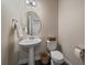 Charming half bathroom with pedestal sink, modern fixtures, and decorative accents at 6805 Canosa St, Denver, CO 80221