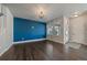 Spacious living room with hardwood floors, blue accent wall, and modern light fixture at 6805 Canosa St, Denver, CO 80221