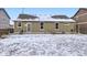 Exterior home view with a snow covered backyard, lawn and patio at 1945 Basil St, Strasburg, CO 80136