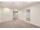 Spacious bedroom featuring neutral carpeting, light filled with an adjacent hallway and a large mirror on the wall at 1945 Basil St, Strasburg, CO 80136