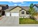 Charming home featuring a three-car garage, manicured lawn, and inviting front porch at 1945 Basil St, Strasburg, CO 80136