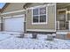 Exterior of a home with a three-car garage, featuring neutral siding and snowy front yard at 1945 Basil St, Strasburg, CO 80136
