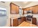Cozy kitchen features stainless steel appliances, wood cabinets, and granite countertops at 1945 Basil St, Strasburg, CO 80136