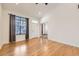 Bright living room with hardwood floors, a large window, and an inviting entrance at 1945 Basil St, Strasburg, CO 80136