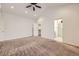 Large main bedroom featuring a vaulted ceiling, ceiling fan, carpet, and ensuite bathroom access at 1945 Basil St, Strasburg, CO 80136