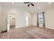 Spacious main bedroom with vaulted ceiling, ceiling fan, ensuite bathroom, and walk-in closet at 1945 Basil St, Strasburg, CO 80136