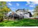 Multi-story home with expansive deck overlooking a landscaped lawn dotted with fall foliage against a blue sky at 2356 Hiwan Dr # 40, Evergreen, CO 80439