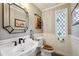 Elegant bathroom with a pedestal sink, vintage toilet and a unique stained glass window at 2356 Hiwan Dr # 40, Evergreen, CO 80439