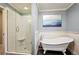Bathroom featuring a vintage clawfoot tub and tiled walk-in shower at 2356 Hiwan Dr # 40, Evergreen, CO 80439