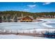 Charming lakeside retreat featuring log cabin architecture, stone accents, and tranquil winter scenery at 2356 Hiwan Dr # 40, Evergreen, CO 80439