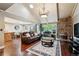 Spacious living room featuring a stone fireplace, vaulted ceilings, and abundant natural light at 2356 Hiwan Dr # 40, Evergreen, CO 80439