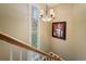 Staircase featuring a stained glass window, a chandelier and eye-catching artwork at 2356 Hiwan Dr # 40, Evergreen, CO 80439