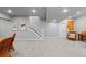 Spacious basement area boasting neutral walls and carpet, as well as stylish wicker chairs and stairway access at 2020 Sagerock Dr, Castle Pines, CO 80108