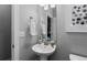 Small half-bath with a pedestal sink, modern fixtures, and decorative artwork at 2020 Sagerock Dr, Castle Pines, CO 80108