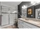 Stylish bathroom featuring a glass enclosed shower, double vanity, and dark accent wall at 2020 Sagerock Dr, Castle Pines, CO 80108
