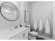 Bright bathroom featuring a round mirror, patterned tile floor, and white towels hung on hooks at 2020 Sagerock Dr, Castle Pines, CO 80108