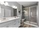 Elegant bathroom with a double vanity, a glass enclosed shower, and modern fixtures at 2020 Sagerock Dr, Castle Pines, CO 80108