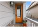 Inviting front entry door with glass panel, bright paint, house number, and a welcoming porch at 2020 Sagerock Dr, Castle Pines, CO 80108