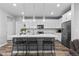 Modern kitchen featuring a center island with bar seating, stainless steel appliances, and white cabinetry at 2020 Sagerock Dr, Castle Pines, CO 80108