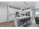 Modern white kitchen featuring an island with bar seating and pendant lighting at 2020 Sagerock Dr, Castle Pines, CO 80108