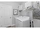 Bright laundry area featuring a washer and dryer, plus storage shelves with supplies and a stylish decorative mirror at 2020 Sagerock Dr, Castle Pines, CO 80108