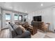 Inviting living room with large windows, comfortable sofa, wooden table, and a decorative entertainment center at 2020 Sagerock Dr, Castle Pines, CO 80108
