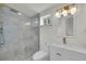 Bright bathroom with a glass shower, white cabinets, marble countertops and gold hardware at 671 Elati St, Denver, CO 80204