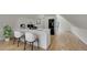 Kitchen featuring white cabinets, stainless appliances, island with seating, and hardwood floors at 671 Elati St, Denver, CO 80204