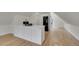 Spacious kitchen with stainless appliances, white cabinets, large island and hardwood floors at 671 Elati St, Denver, CO 80204