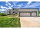 Charming exterior of two-story home featuring a spacious three-car garage and landscaped front yard at 9163 N Palomino Dr, Castle Rock, CO 80108