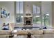 Bright living room with a brick fireplace, vaulted ceilings, and large windows offering scenic views at 9163 N Palomino Dr, Castle Rock, CO 80108
