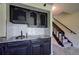 Close-up of wet bar in finished basement, features custom cabinetry and granite counters at 9163 N Palomino Dr, Castle Rock, CO 80108