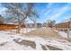 Cute bungalow with a fenced front yard and snowy landscape at 15235 W 43Rd Ave, Golden, CO 80403