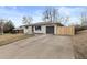 Well-kept one-story home with long driveway, modern garage door, and privacy fence at 2765 S Winona Ct, Denver, CO 80236