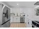 Modern kitchen featuring white cabinets, stainless steel appliances, and hardwood floors at 2765 S Winona Ct, Denver, CO 80236