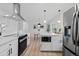 Modern kitchen featuring white cabinets, stainless steel appliances, and an adjacent dining area at 2765 S Winona Ct, Denver, CO 80236