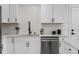Modern kitchen with white cabinets, subway tile backsplash, stainless steel appliances, and stylish black fixtures at 2765 S Winona Ct, Denver, CO 80236