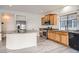 Modern kitchen with stainless steel appliances, wood cabinets, granite countertops, and light hardwood-style flooring at 4404 Walden St, Denver, CO 80249