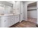 Main bathroom with double vanity, white cabinets, and vinyl plank flooring at 3484 N Irvington St, Aurora, CO 80019