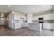 Open concept kitchen features white cabinets, an island, and hardwood-look floors at 3484 N Irvington St, Aurora, CO 80019