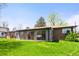 Grassy backyard featuring an enclosed sunroom attached to the home at 6212 S Pennsylvania St, Centennial, CO 80121