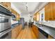 Spacious kitchen featuring stainless steel appliances, wooden cabinets, and wood-look floors at 6212 S Pennsylvania St, Centennial, CO 80121