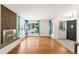 Bright living room with hardwood floors, a brick fireplace, and large windows at 6212 S Pennsylvania St, Centennial, CO 80121