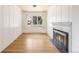 Bright living room featuring a fireplace, wood floors and a large window at 6212 S Pennsylvania St, Centennial, CO 80121