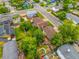 Aerial view displays a well-manicured lawn, mature trees, and deck with a seating area at 9832 High St, Thornton, CO 80229